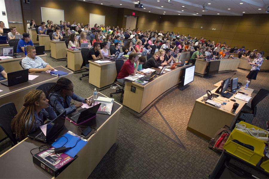 A faculty member speaks in front of a class.