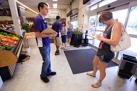 Student workers collect survey responses at an area grocery story for for a FERC research project.